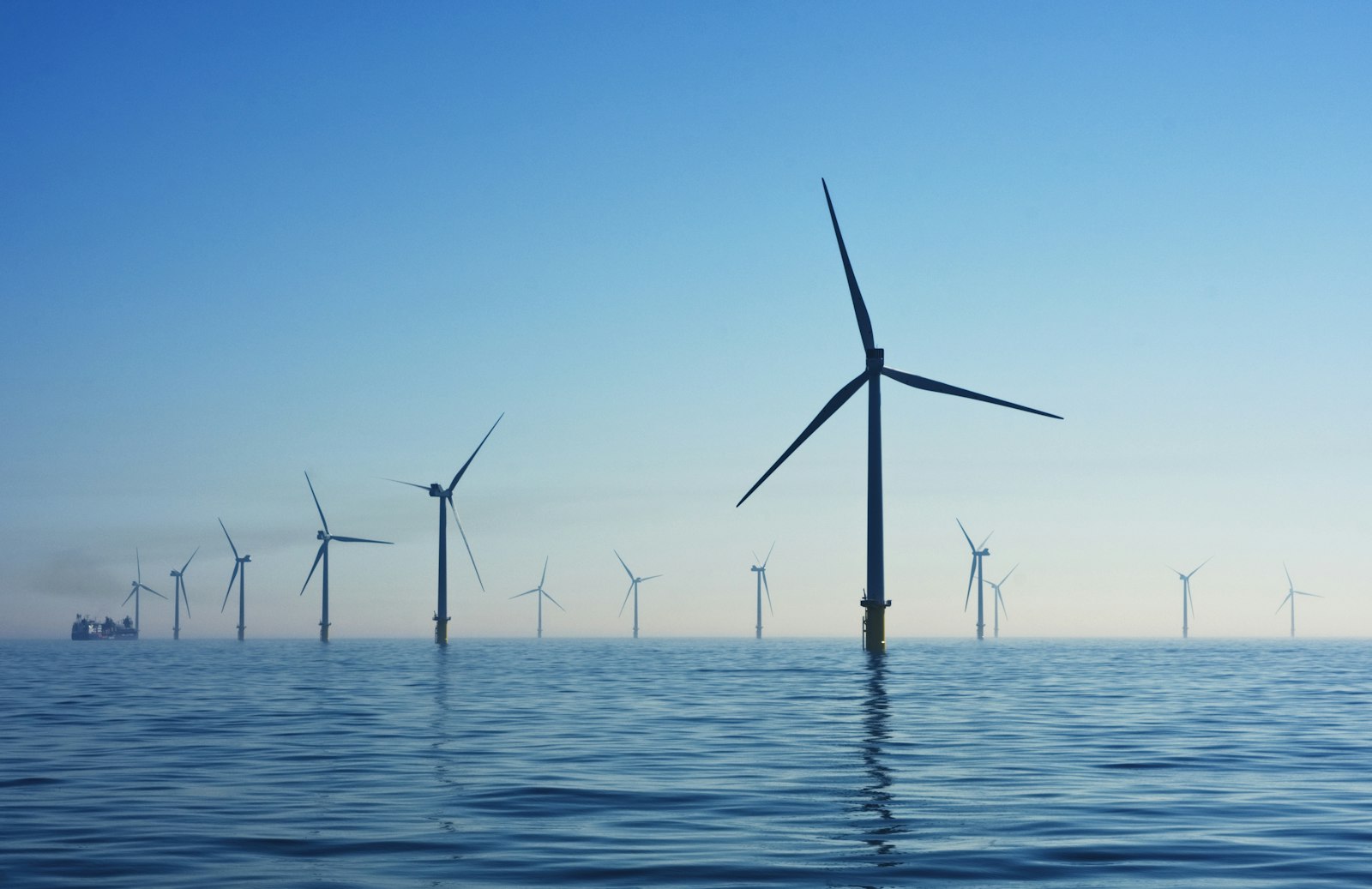 Windkraftanlage im Betrieb vor blauem Himmel